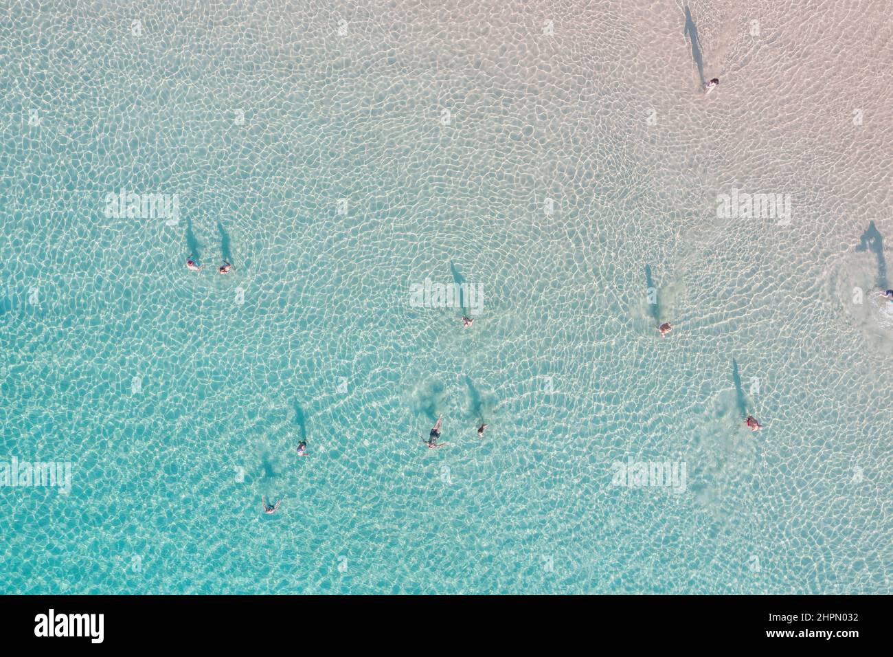 Die Menschen schwimmen in türkisblauem Meereswasser Luftbild. Flacher Wasserspaß unter griechischer Sonne. Sonniger Sommertag, Reiseziel Stockfoto
