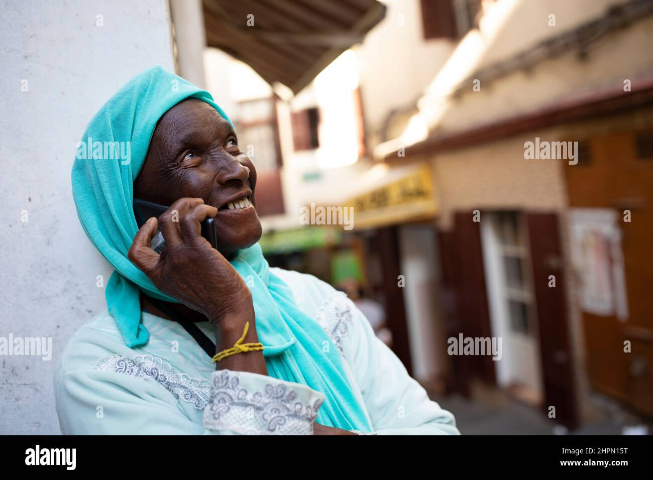 Ein Einwanderer aus dem Senegal spricht mit seiner Familie in der alten Medina in Tanger, Marokko, Nordafrika. Stockfoto