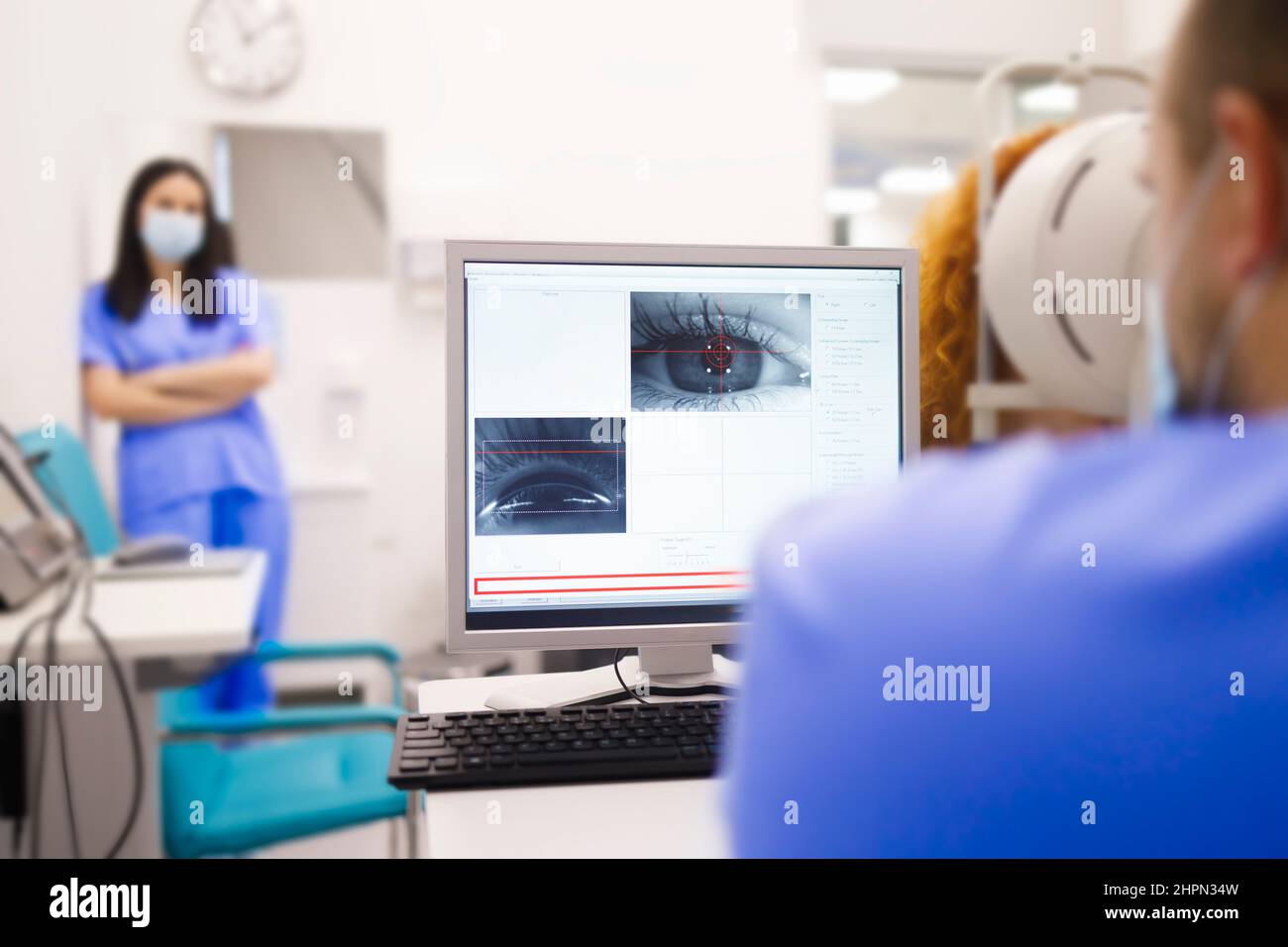 Ein Techniker, der eine Augenuntersuchung für seinen Patienten durchführt Stockfoto