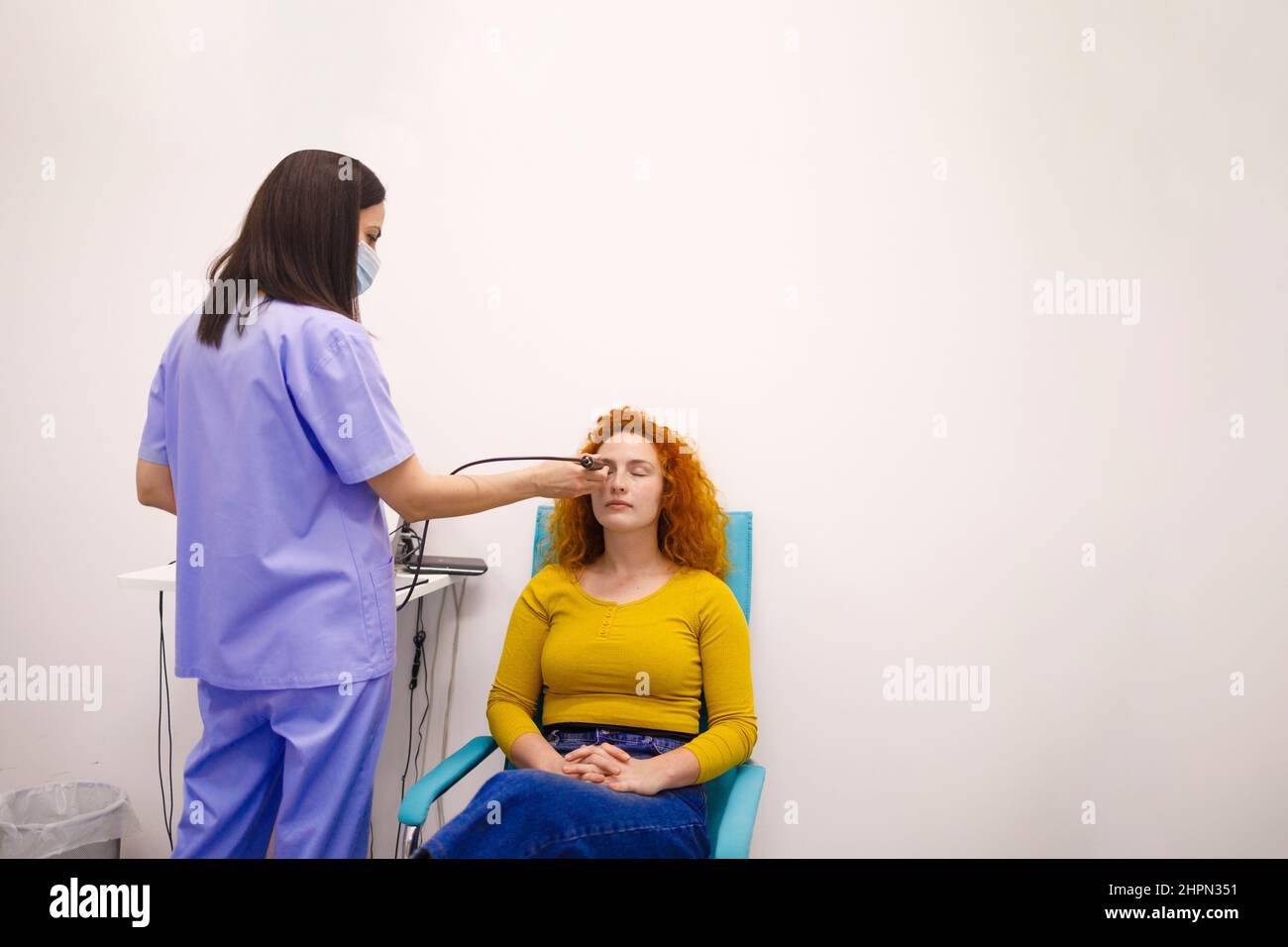 Ärztin, die die Augen ihrer Patientin und der Augenklinik inspiziert Stockfoto