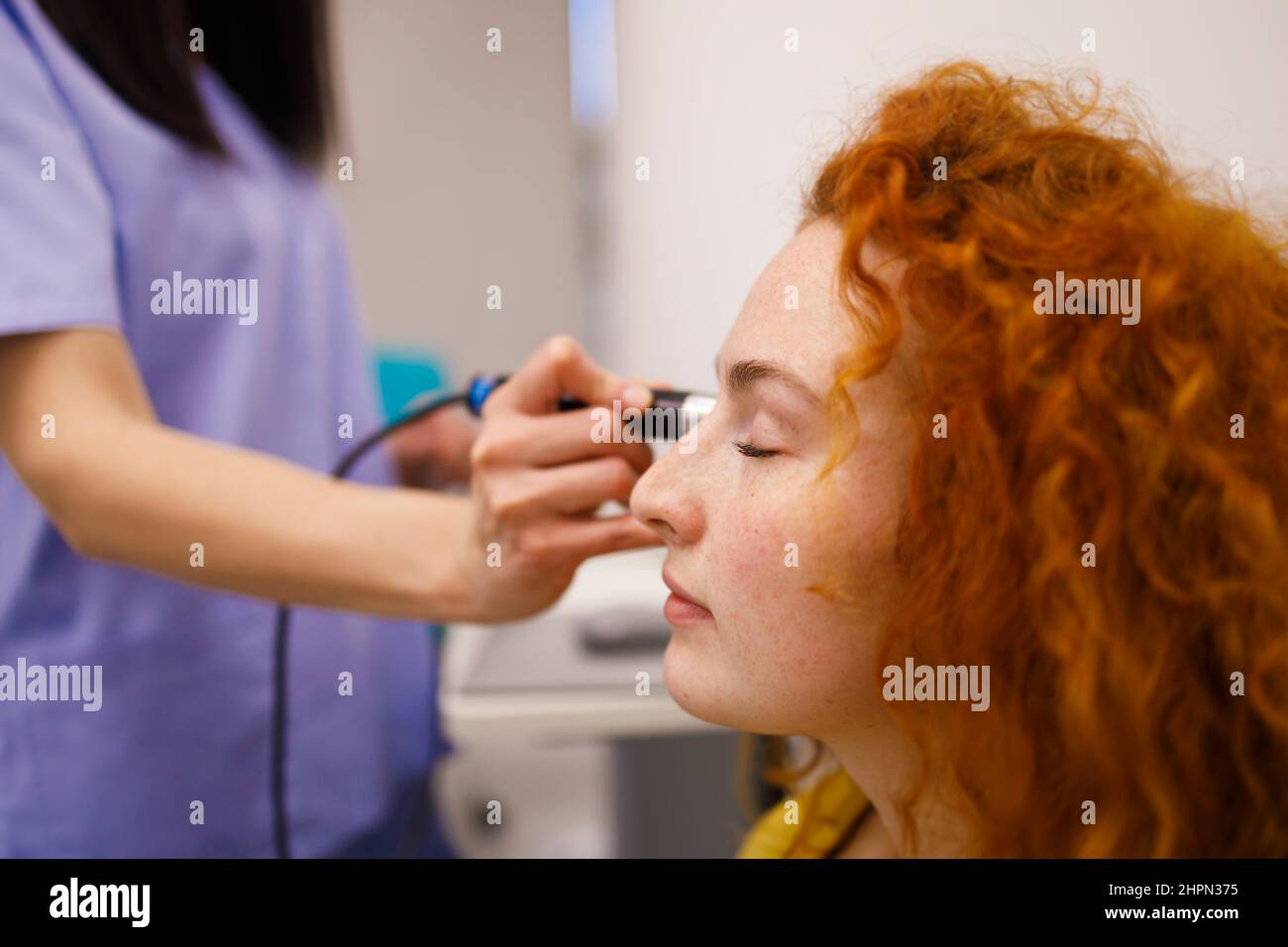 Weibliche Patientin, die den Augendruck in ihrer örtlichen Klinik überprüft Stockfoto