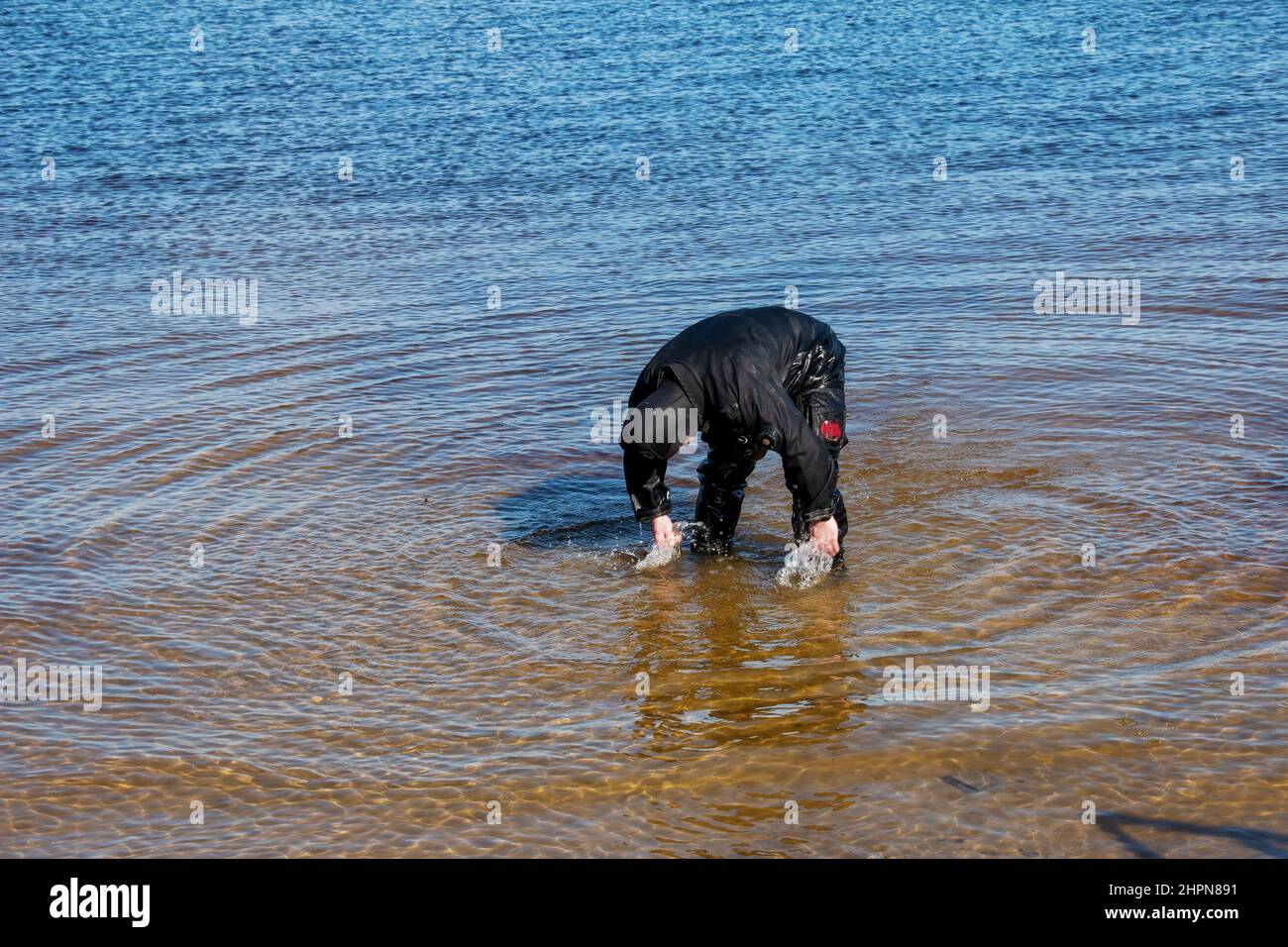 Professioneller Taucher in der Nähe der Flussküste. Kommerzielles Tauchen. Winter. Stockfoto