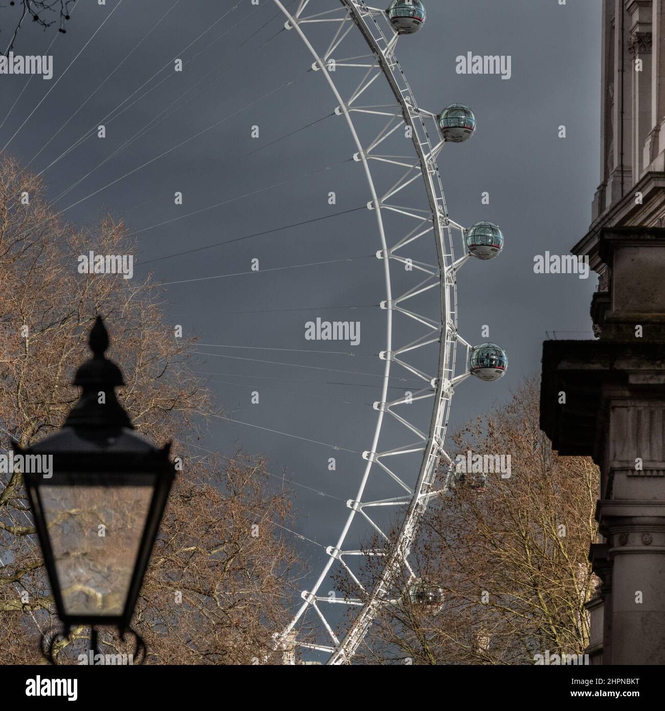 London, Großbritannien. 22nd. Februar 2022. An diesem Nachmittag hängen dunkle Wolken über Westminster. Das London Eye und eine historische Straßenbeleuchtung sind von der Downing Street im Zentrum Londons aus zu sehen. Kredit: Imageplotter/Alamy Live Nachrichten Stockfoto