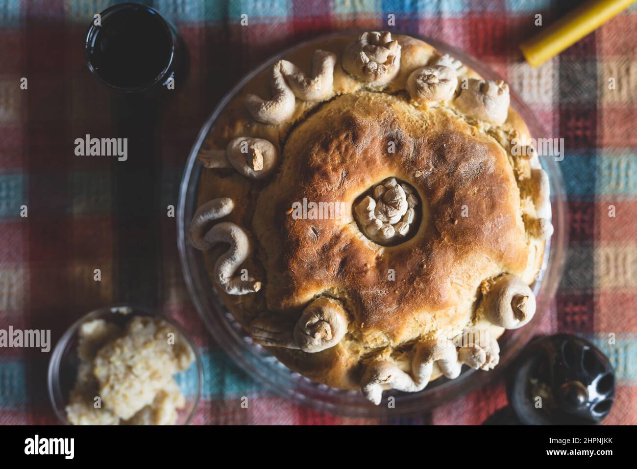 Der Familienvater hält die Feier des schutzpatrons Ein hausgemachtes Slava-Kuchenbrot von oben auf dem Tisch, um traditionelle Gerichte zu feiern, die für einen orthodoxen Urlaub zubereitet werden Stockfoto