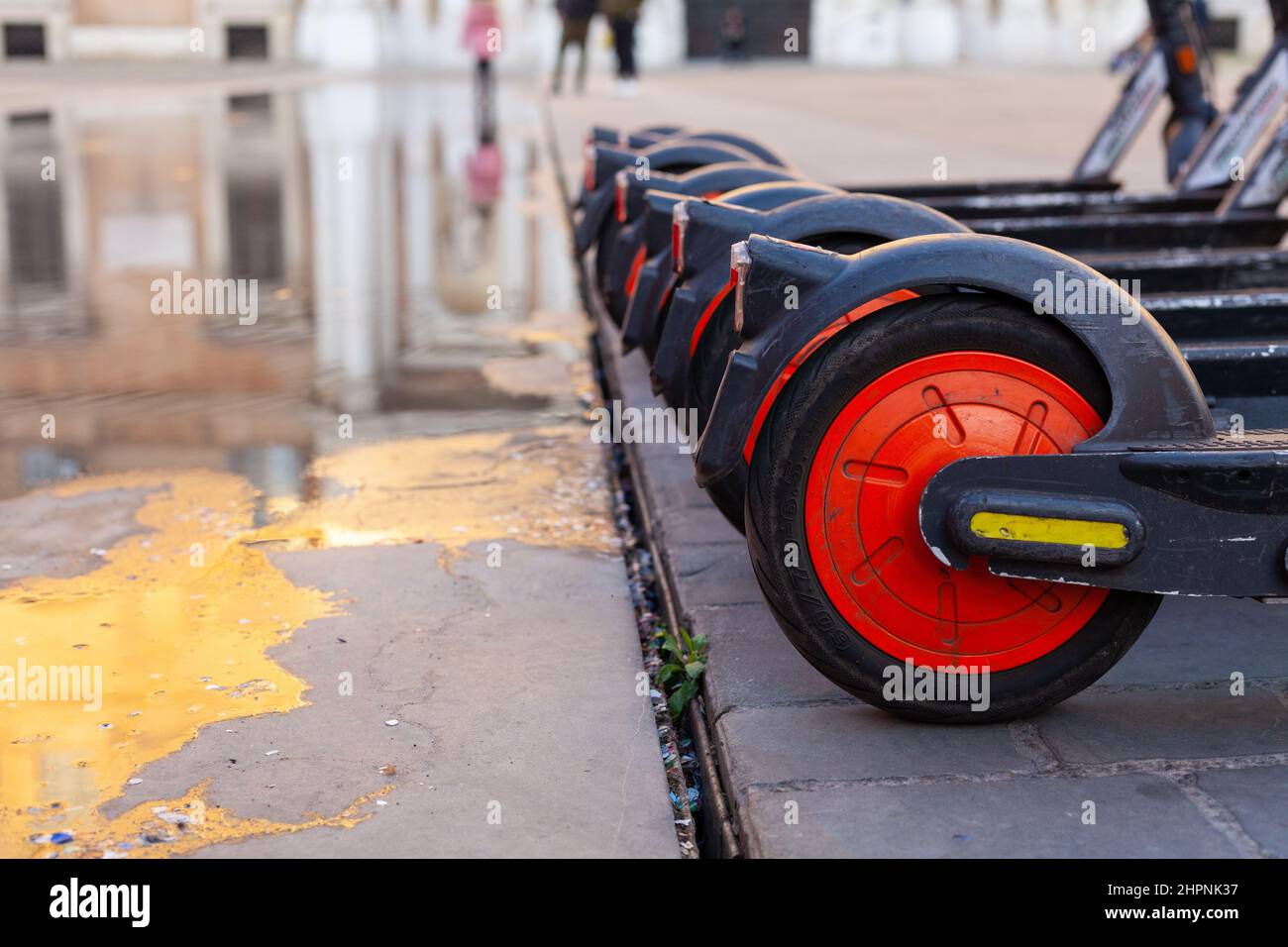 Eine Reihe von Teilen Elektroroller Räder auf einem öffentlichen Stadtplatz in Modena, Italien Stockfoto