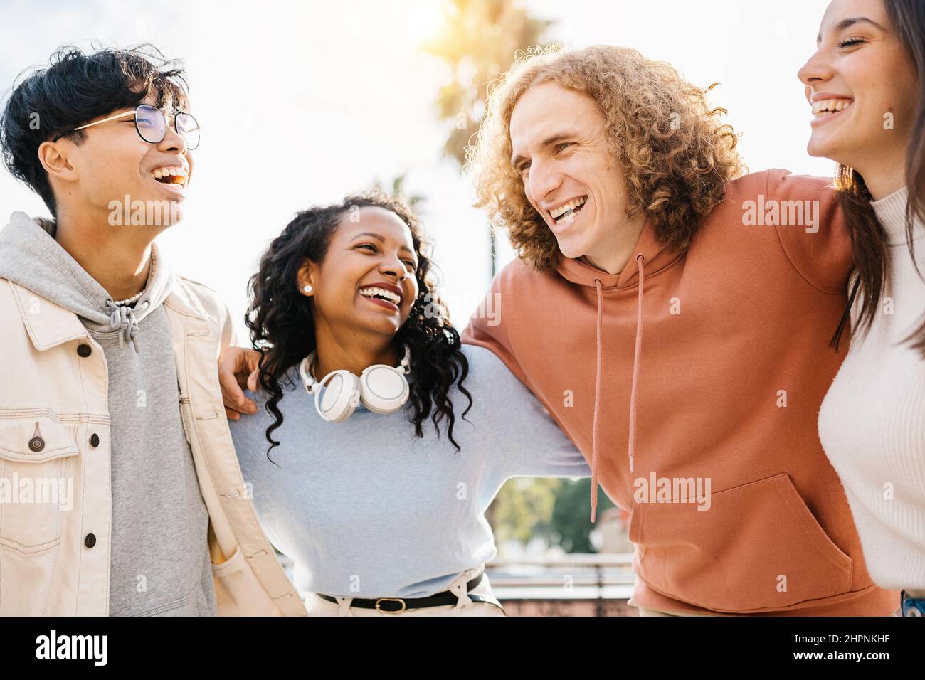 Gruppe von glücklichen jungen, vielfältigen Teenagerfreunden, die im Freien zusammen lachen Stockfoto