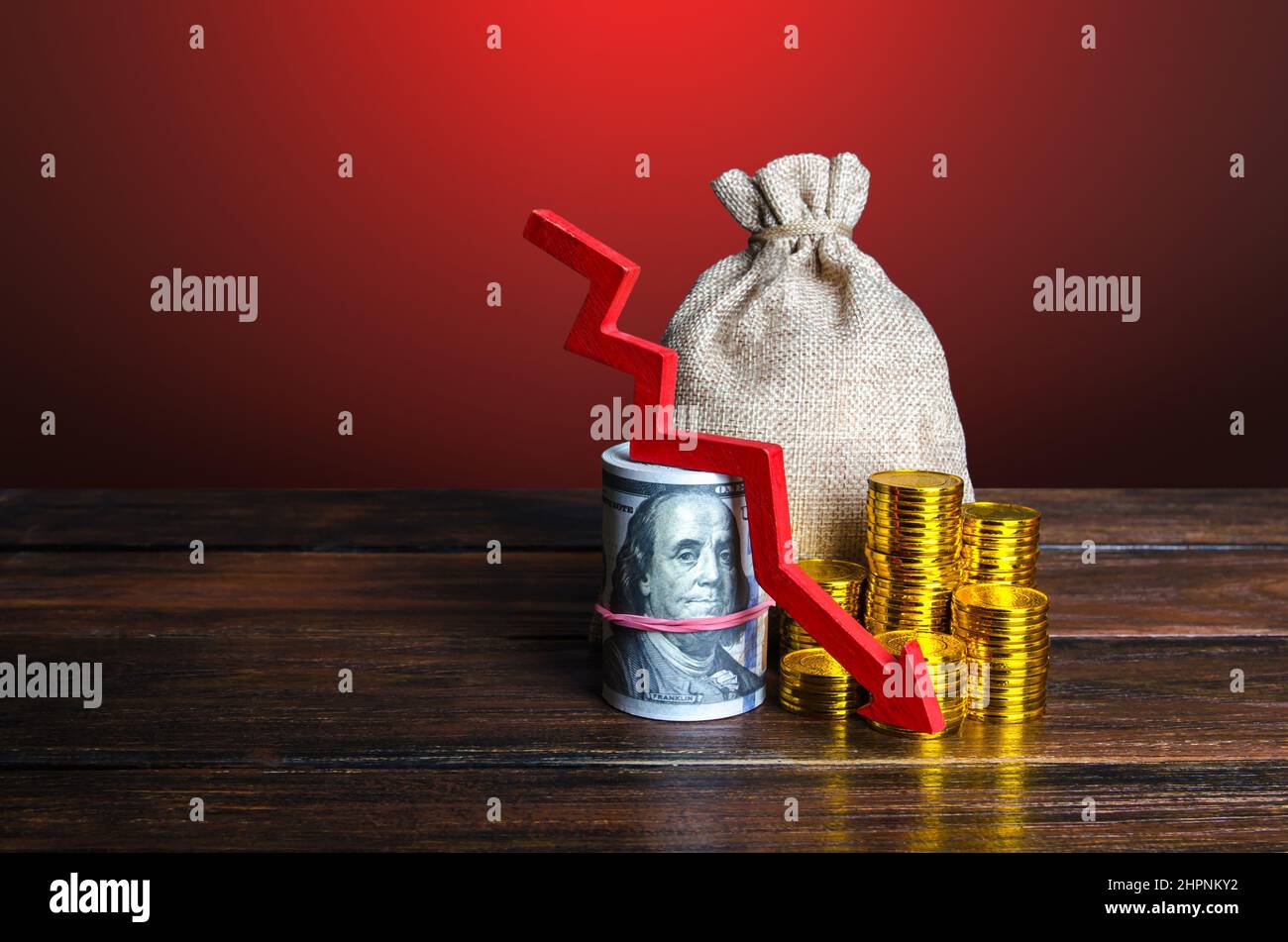Geld mit rotem Pfeil nach unten. Weniger Geld und Geld. Rückgang der Wirtschaft, Kapitalreduzierung. Senkung der Ersparnisse und Reserven. Inflation. Sinkende Einkommen Stockfoto