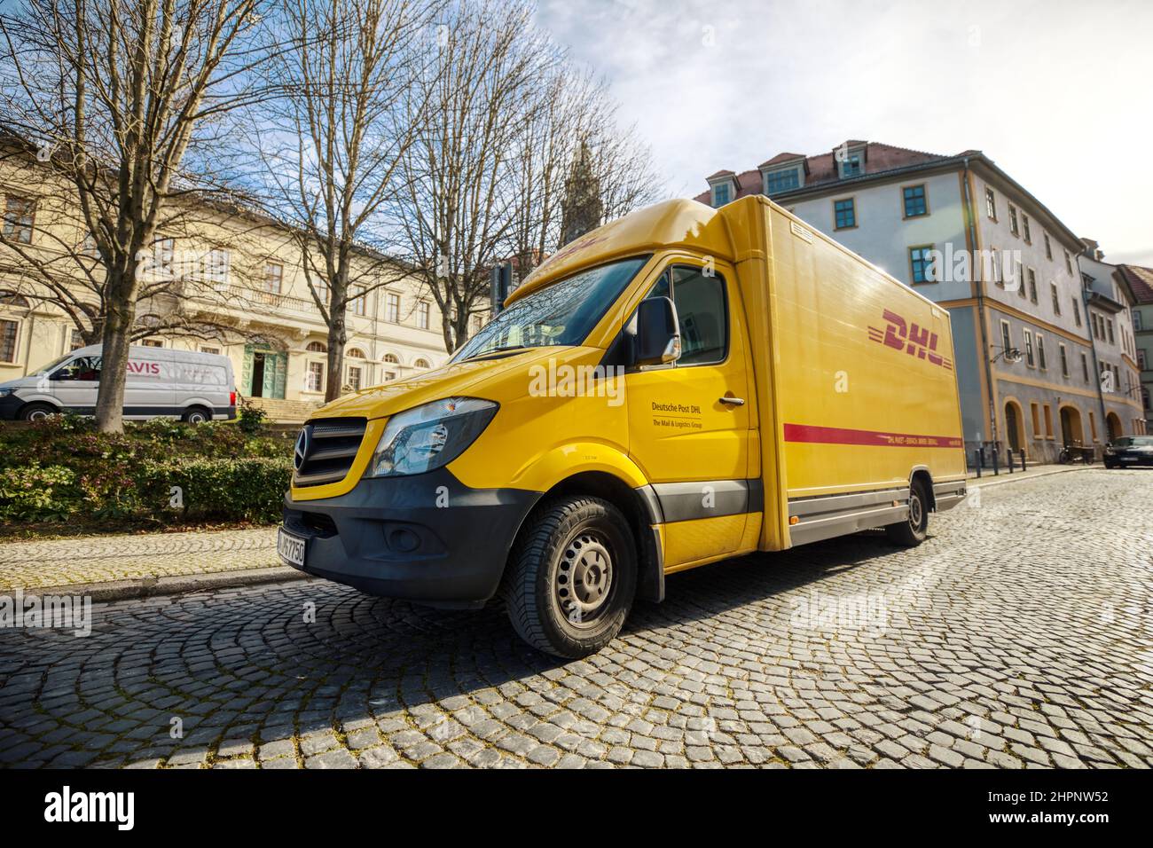 Weimar, Deutschland - 21. Februar 2022: Deutscher Pakettransporter von DHL steht in einer Fußgängerzone, um Pakete zu laden Stockfoto