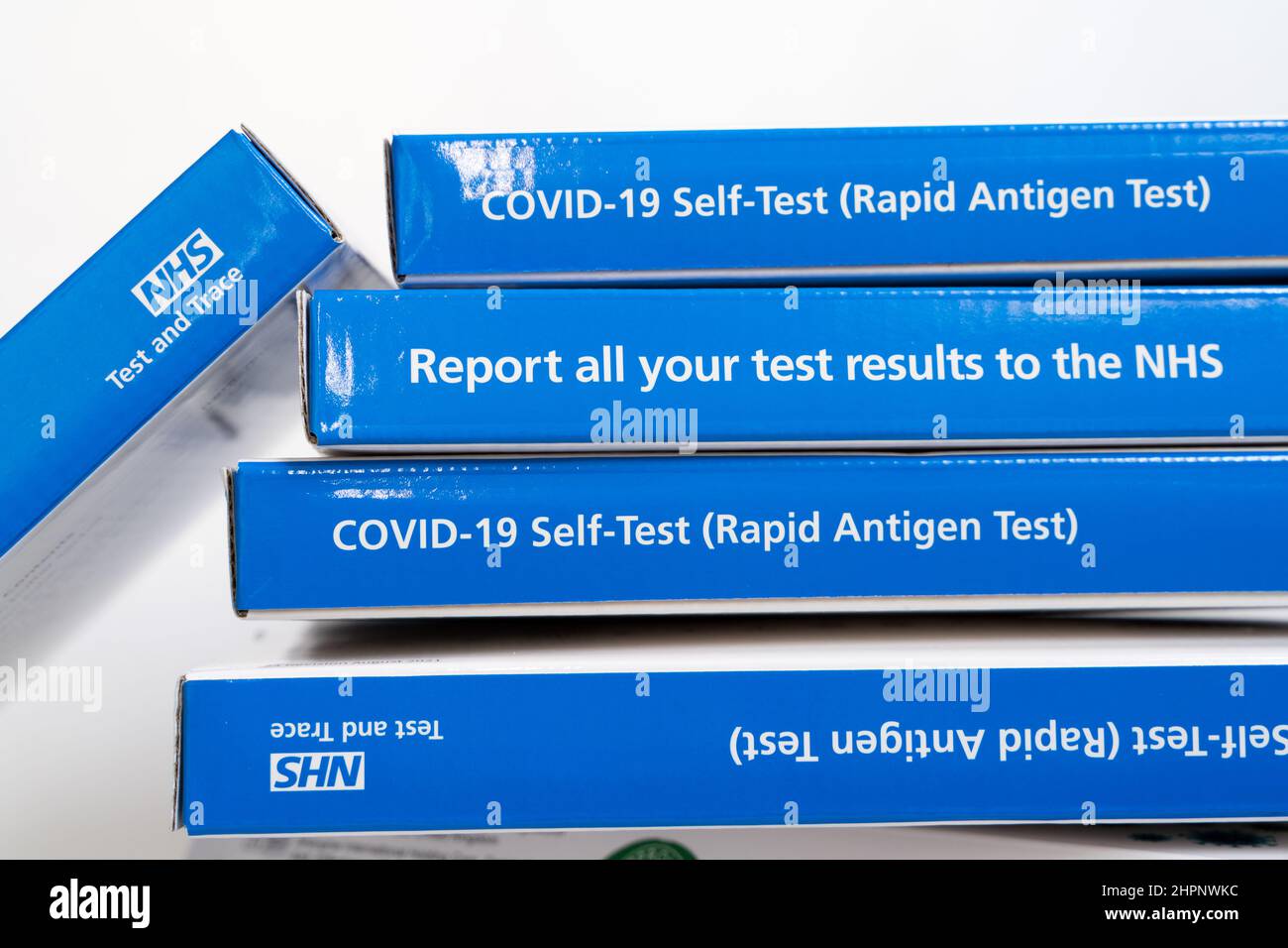 Stapel von Kartons mit COVID-19 Selbsttest-Kits, die von NHS England UK geliefert werden Stockfoto
