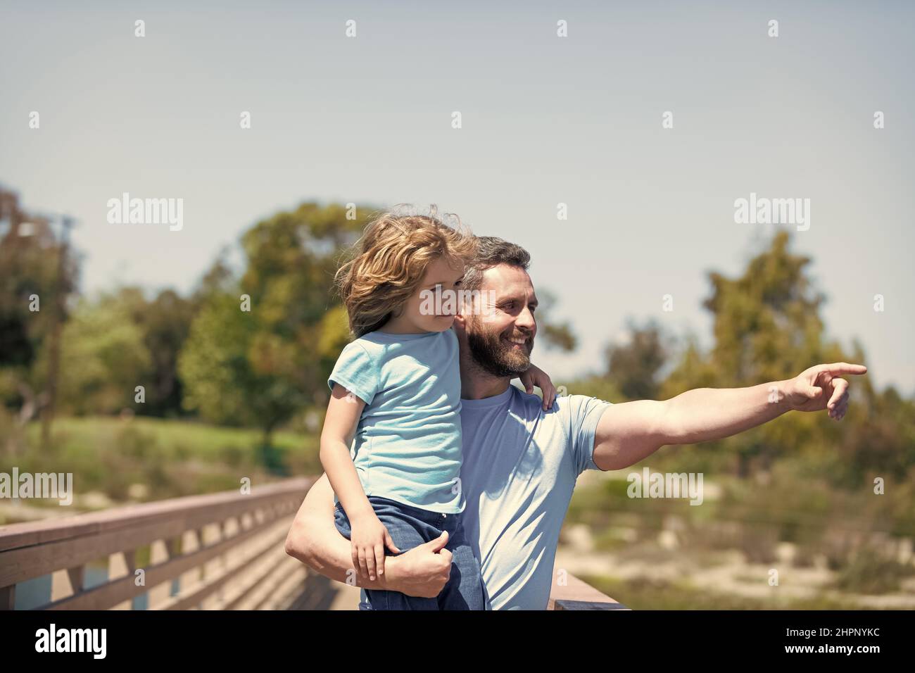 Glücklicher Vater Mann halten Sohn Kind in den Armen zeigt Finger Sommer im Freien, Elternschaft Stockfoto