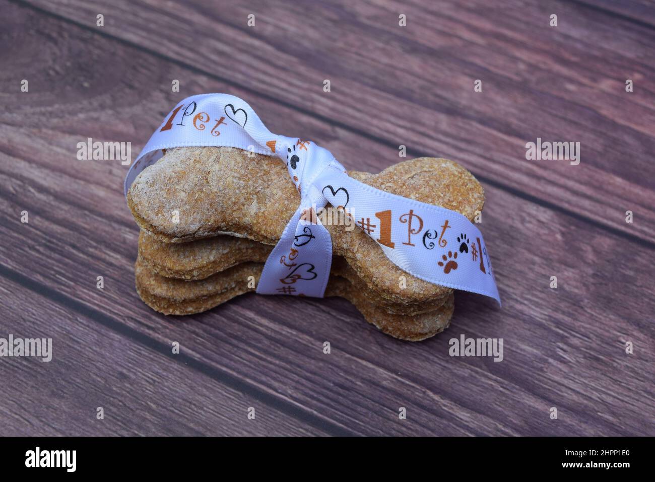 Hausgemachte „knochenförmige“ Hundesnacks, eingewickelt in ein Band mit Tiermotiven. Stockfoto