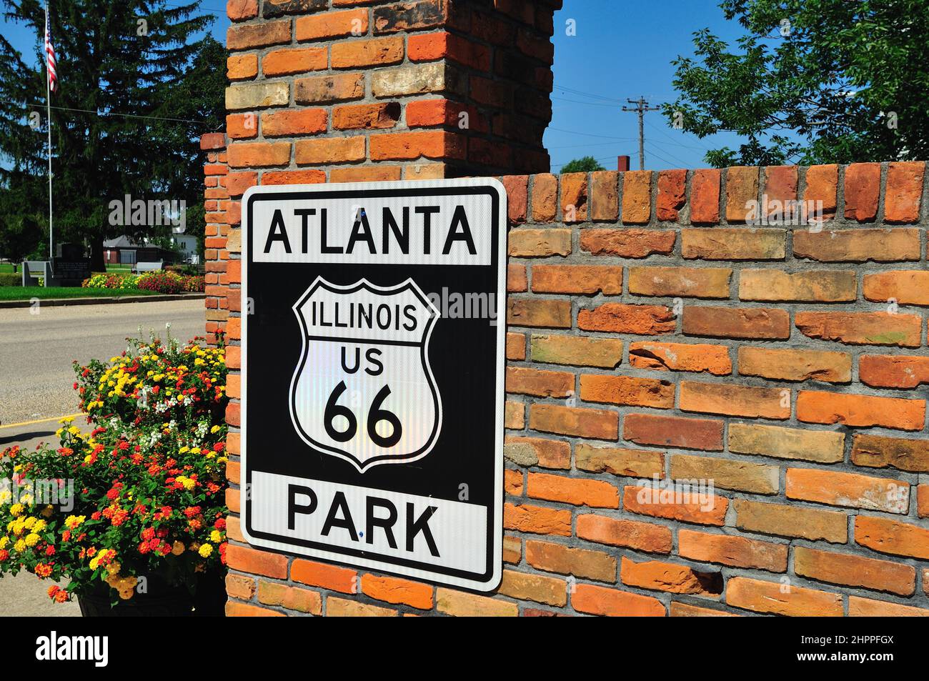 Atlanta, Illinois, USA. Stadt mit Identität zur Mother Road, US Route 66, ein Straßenschild auf einer Backsteinmauer ist eine Hommage an die berühmte Straße. Stockfoto