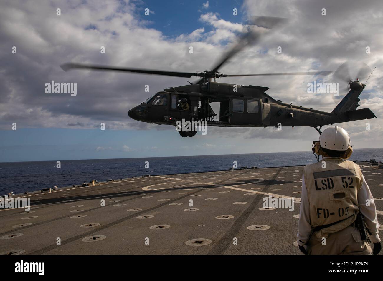 Ein US Army UH-60m Black Hawk bereitet sich auf die Landung auf der USS Pearl Harbor am 18. Februar 2022 im Pazifischen Ozean als Teil des Trainings vor. Die gemeinsame Serviceschulung war Teil einer Qualifikation für die Landung von Deck, die durchgeführt wurde, um die Fähigkeiten zur Unterstützung von Seemissionen in der Indo-Pazifik-Region zu erhalten. (USA Armeefoto von SGT Carlie Lopez/28th Public Affairs Detachment.) Stockfoto