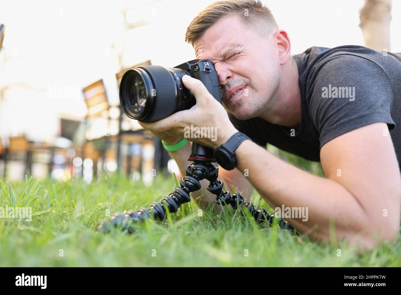 Der Fotograf macht Fotos mit einer modernen Kamera auf einem Stativ im Freien Stockfoto