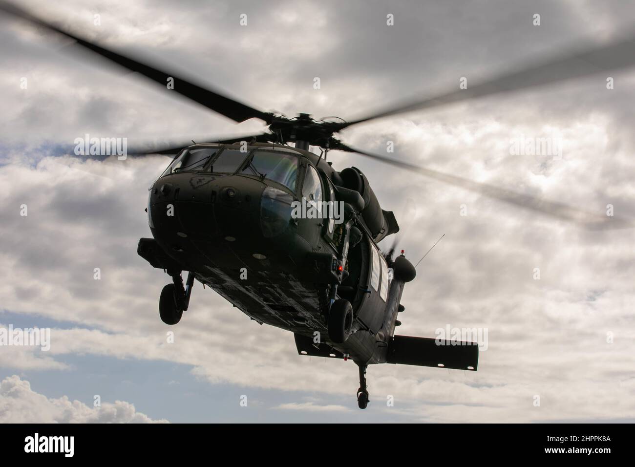 Ein US Army UH-60m Black Hawk fliegt am 18. Februar 2022 im Pazifischen Ozean als Teil des Trainings über die USS Pearl Harbor. Die gemeinsame Serviceschulung war Teil einer Qualifikation für die Landung von Deck, die durchgeführt wurde, um die Fähigkeiten zur Unterstützung von Seemissionen in der Indo-Pazifik-Region zu erhalten. (USA Armeefoto von SGT Carlie Lopez/28th Public Affairs Detachment.) Stockfoto