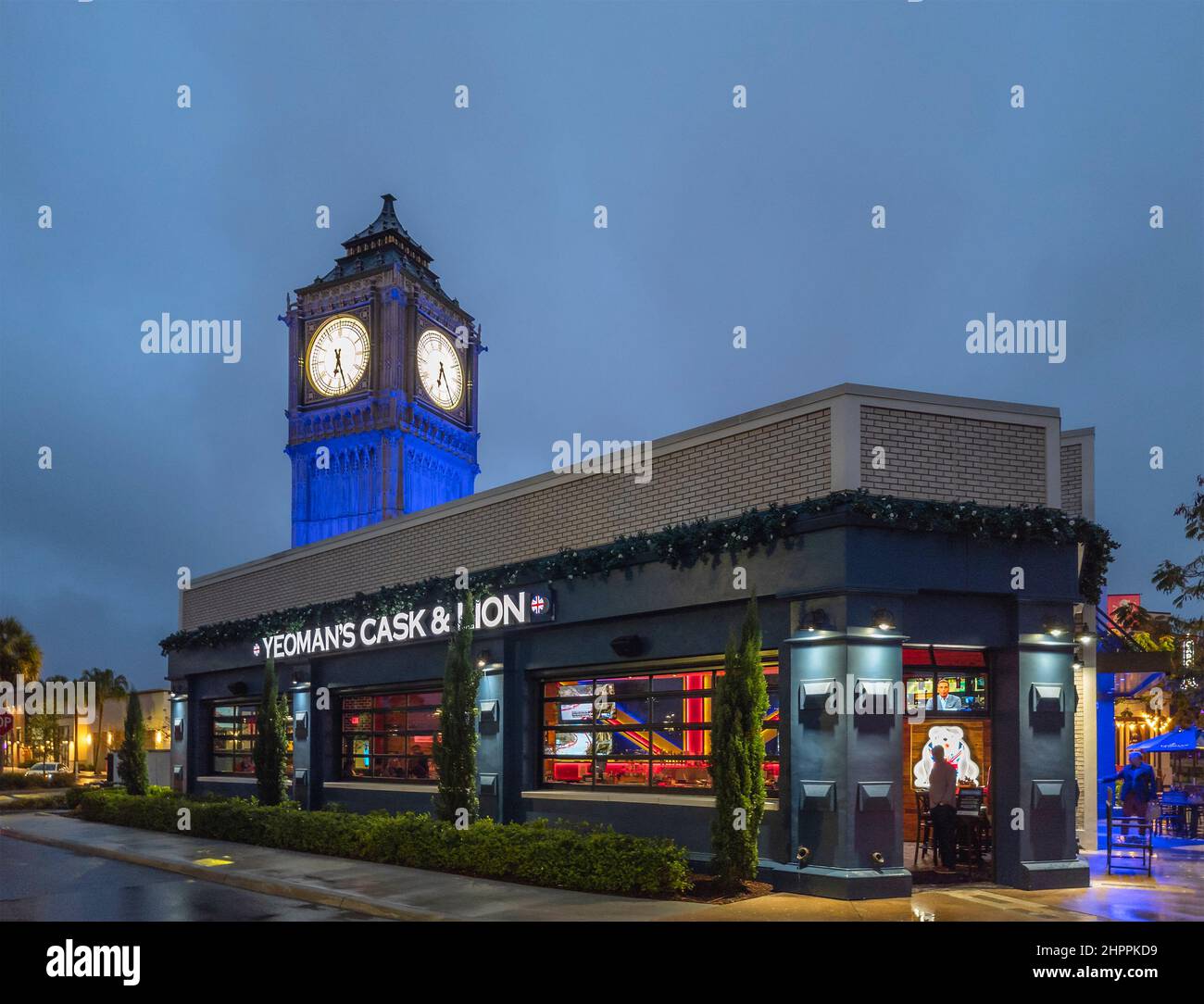Kissimmee, Florida - 5. Februar 2022: Volle Gebäude Nacht Blick auf Yeoman's Cask & Lion mit Big Pen Mini Tower. Yeoman's ist ein britischer Pub und Restaurant Stockfoto