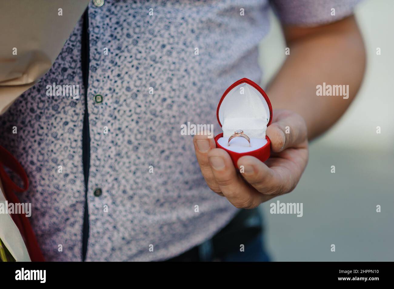 Ein Heiratsangebot. Goldener Ring mit einem Stein in einer roten Schachtel Stockfoto