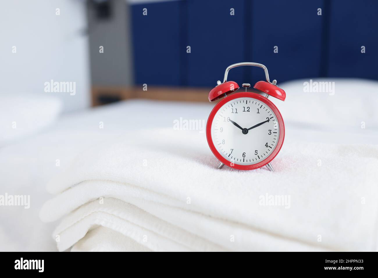 Wecker für 10 Uhr morgens oder abends auf Handtüchern auf den Betten Stockfoto