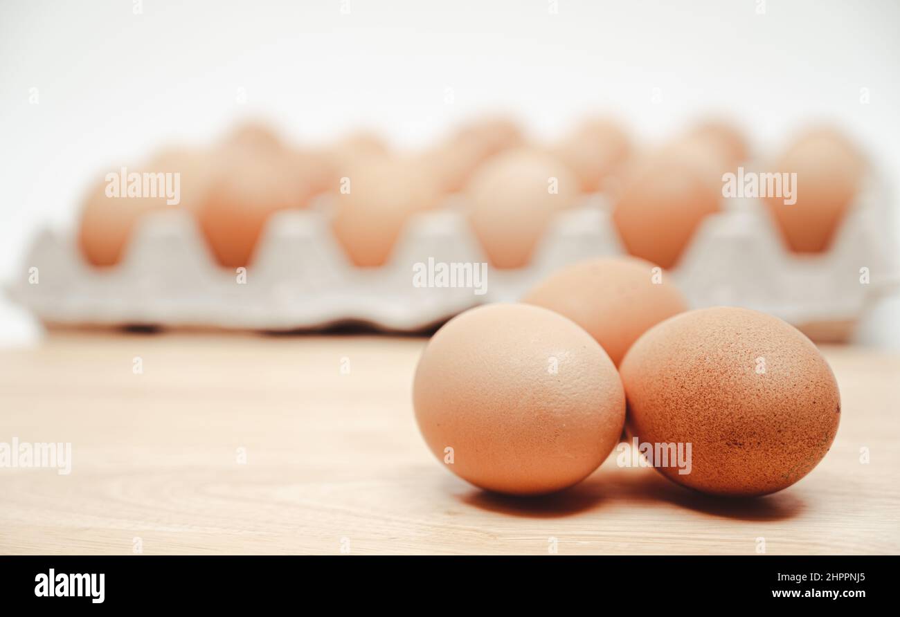 Die Eier auf dem Papiertablett und dem hölzernen Schneidebrett. Stockfoto