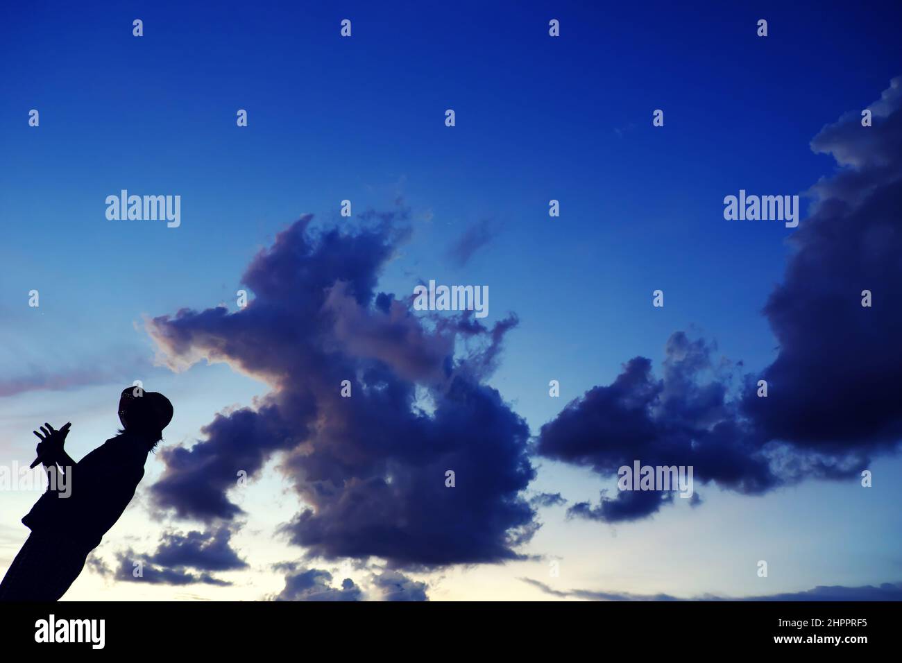 Lustige Szene bei Sonnenuntergang, wenn die Silhouette einer vietnamesischen Frau läuft, wenn die Tierform von der Wolkenjagd kommt, stellt sich die Frau auf dem Dach auf, wenn sie zu Hause in Gesellschaft bleibt Stockfoto