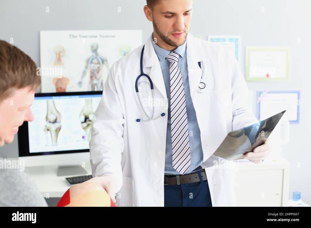 Arzt tragen Uniform und Untersuchung Patienten-Scan, berühren mans Knie Stockfoto