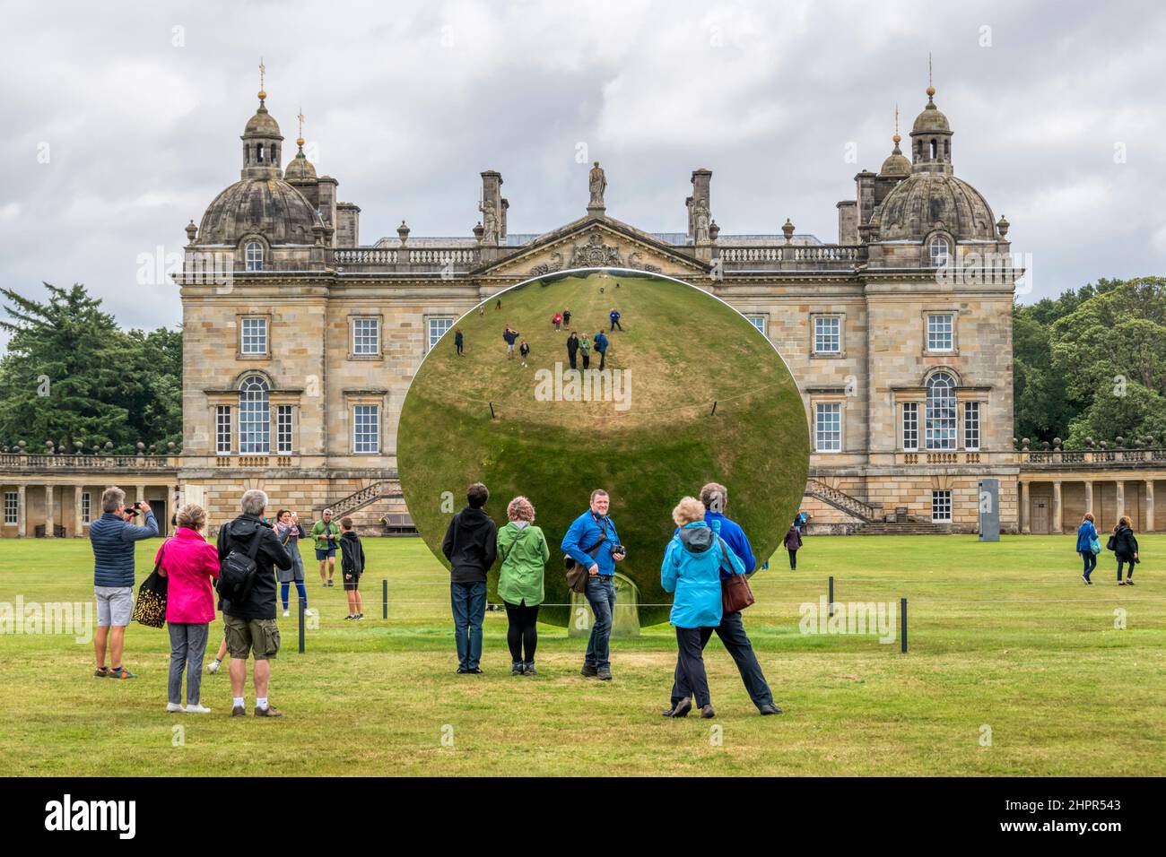 Besucher fotografieren ihre Spiegelungen im hinteren Teil des Sky Mirror von Anish Kapoor auf dem Gelände der Houghton Hall, Norfolk. Edelstahl, 2018. Stockfoto