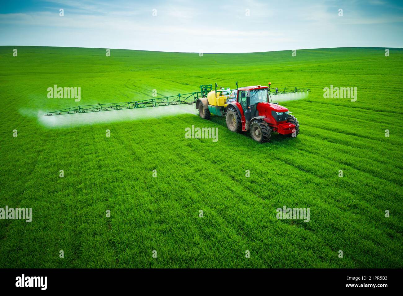 Luftaufnahme von landwirtschaftlichen Traktor Pflügen und Spritzen auf dem Feld. Stockfoto