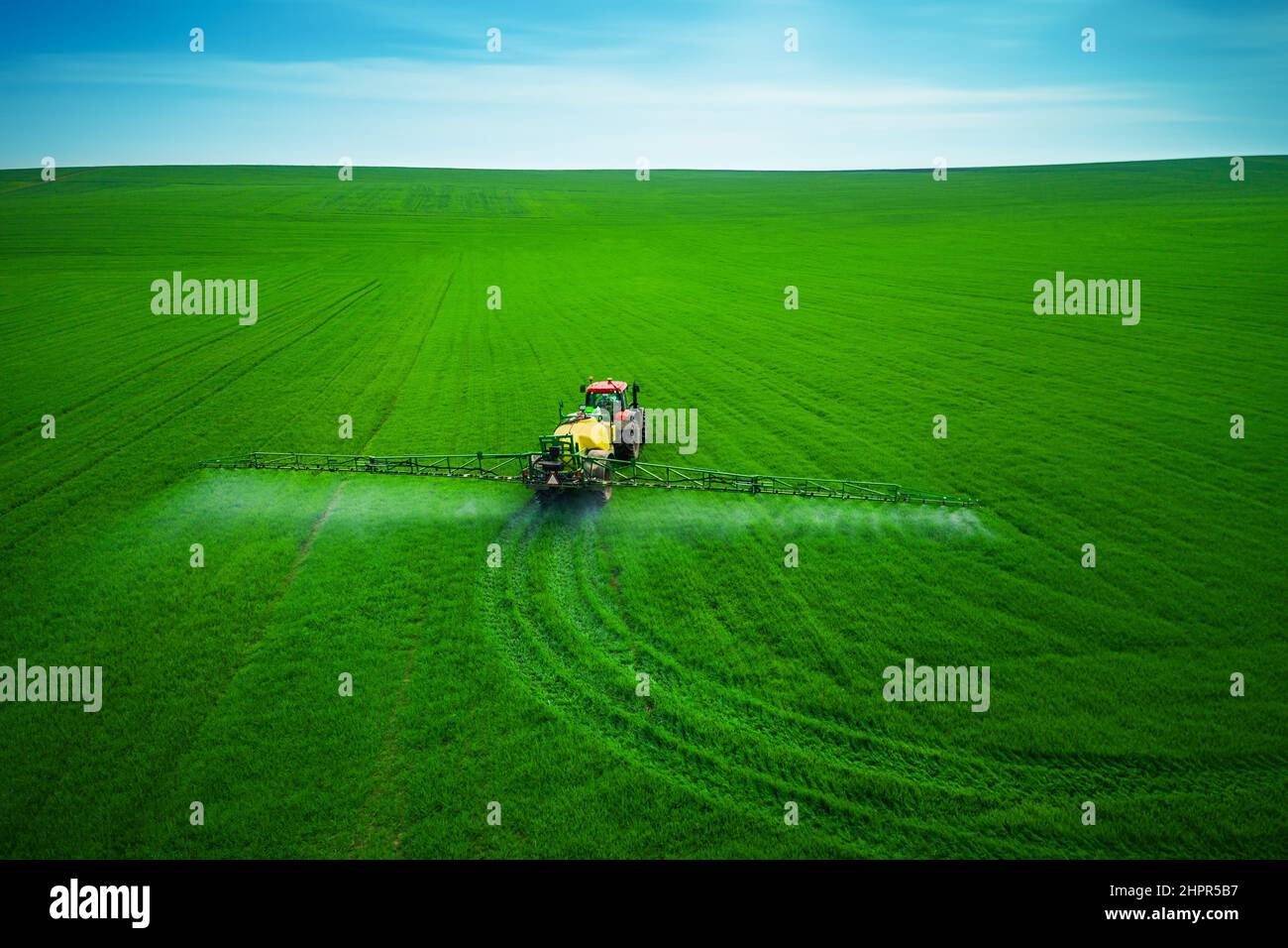 Luftaufnahme von landwirtschaftlichen Traktor Pflügen und Spritzen auf dem Feld. Stockfoto