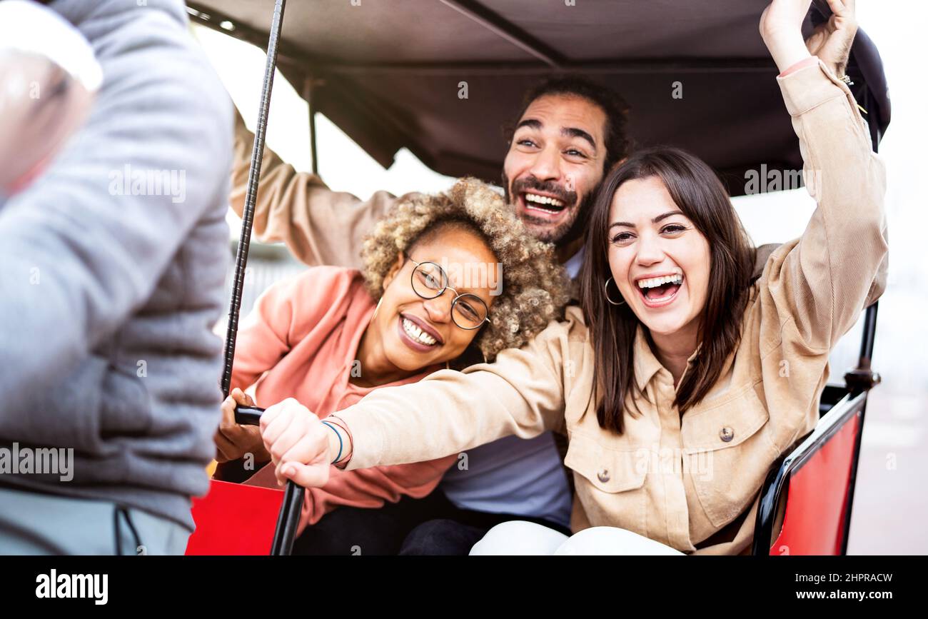 Multirassische Studenten jubeln auf Rikscha am Reisestandort - Life Style Konzept mit Jungs und Mädchen, die Spaß zusammen haben - College-Kollegen reiten aroun Stockfoto