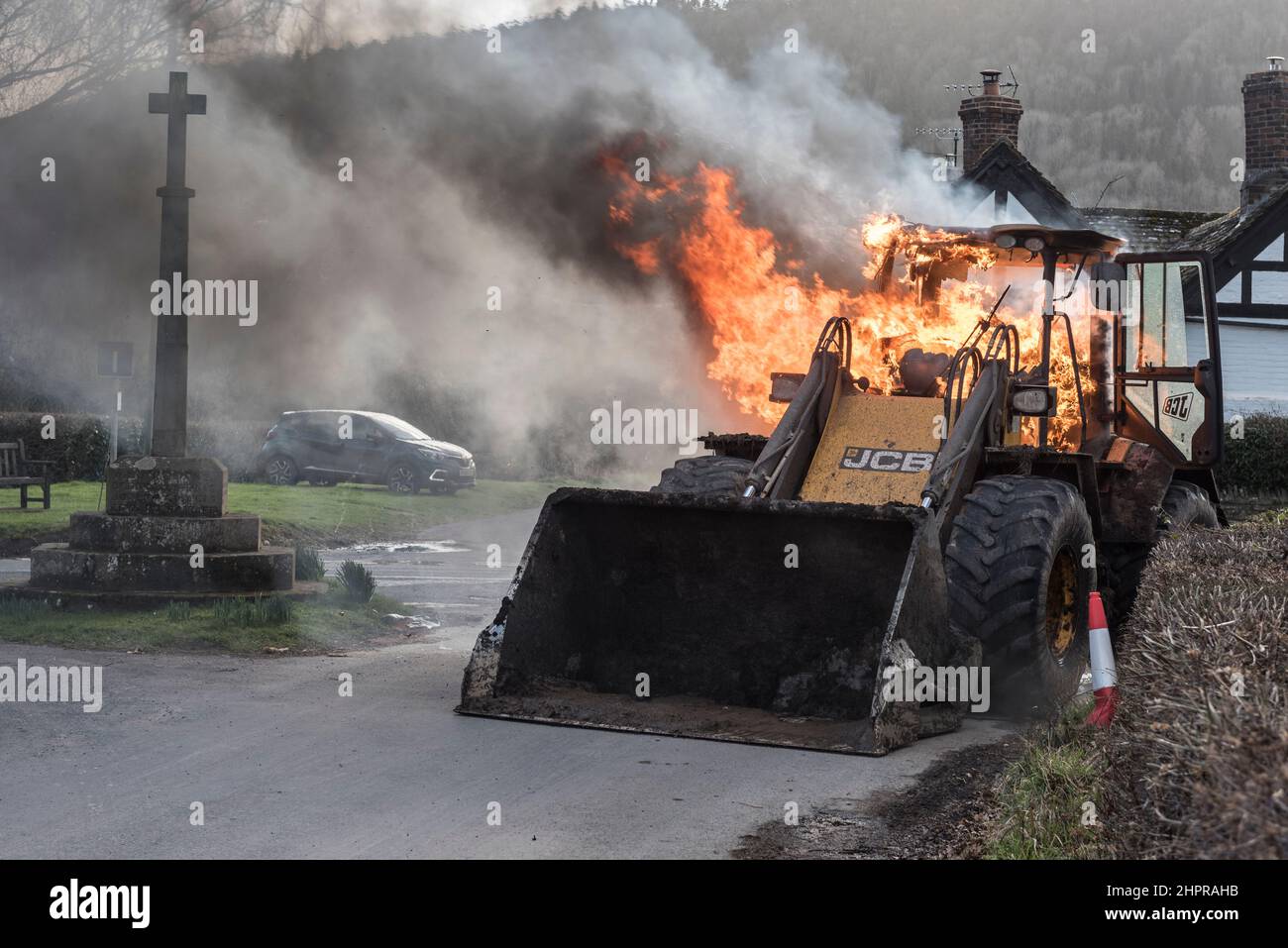 Ein JCB-Bagger, der auf einer Landstraße in der Nähe von Moccas, Herefordshire, Großbritannien, in Brand gesetzt wurde Stockfoto