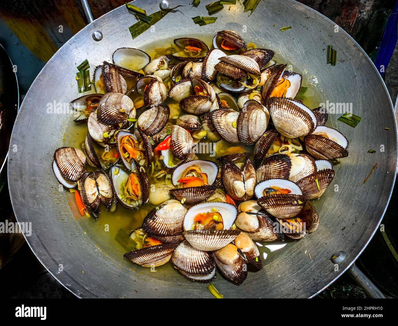 Ein Wok voller gekochter Venusmuscheln in einem Straßenessen-Restaurant in Quy Nhon. Stockfoto