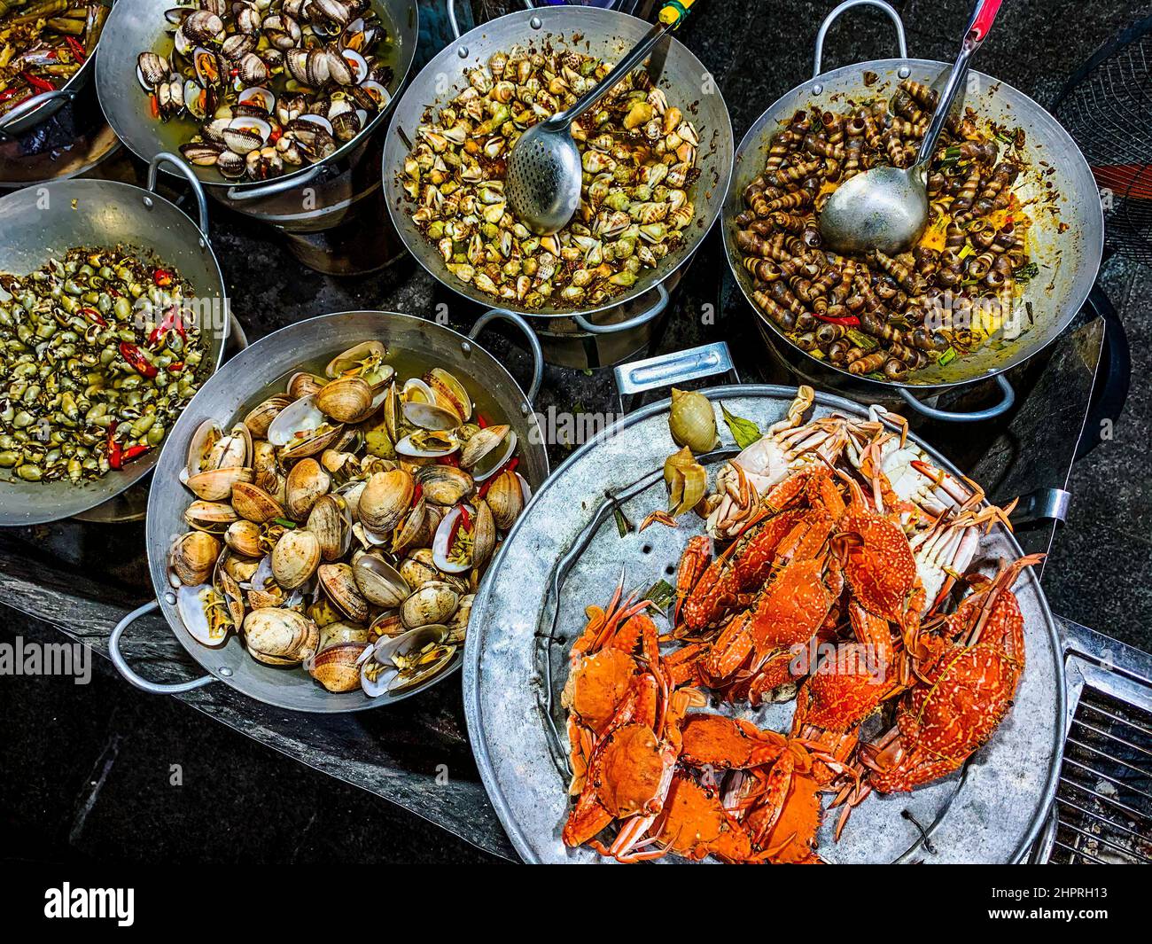 Straßenrestaurant mit Woks mit Meeresfrüchten. Stockfoto