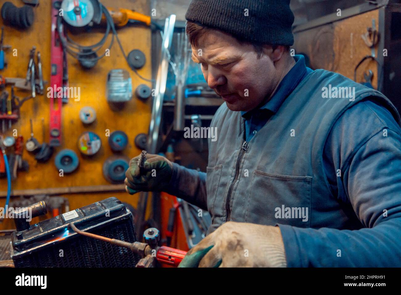 Schweißen eines großen Autokühlers mit einem Gasbrenner Stockfoto