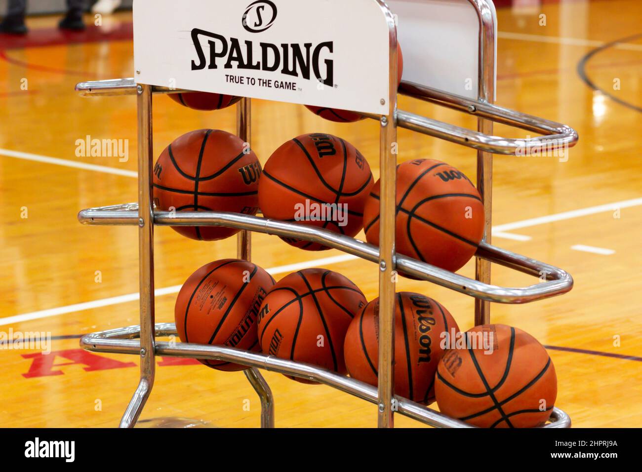 West Islip, New York, USA - 8. Februar 2022: Viele Basketbälle auf einem Regal auf einem halben Platz für beide Teams, die während des Aufwärmens verwendet werden können, Stockfoto