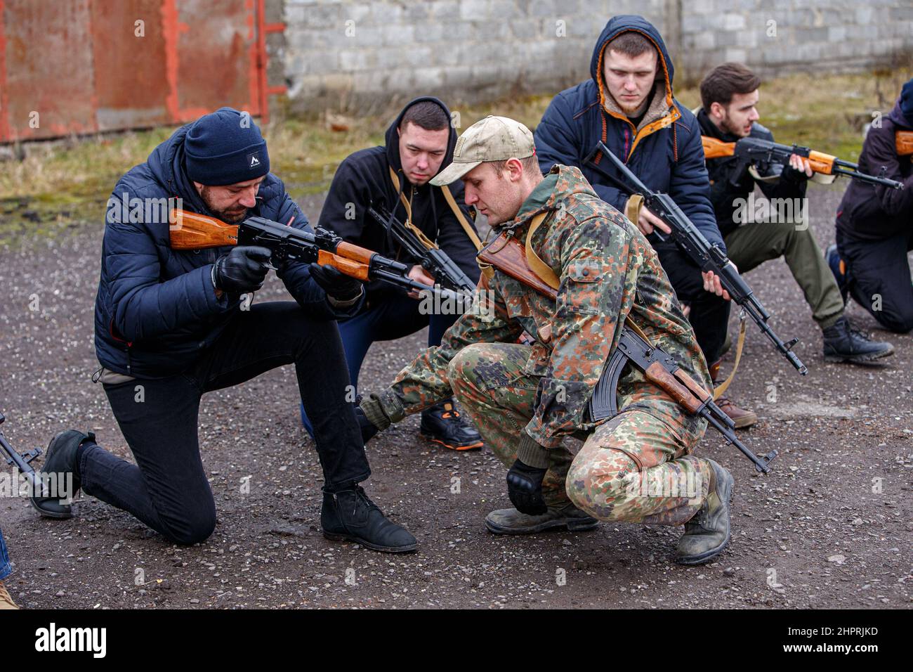 SIURTE, UKRAINE - 19. FEBRUAR 2022 - ein Ausbilder korrigiert die knieende Position des Mannes während einer militärischen Übung für Zivilisten, die durch den Umzug durchgeführt wurde Stockfoto