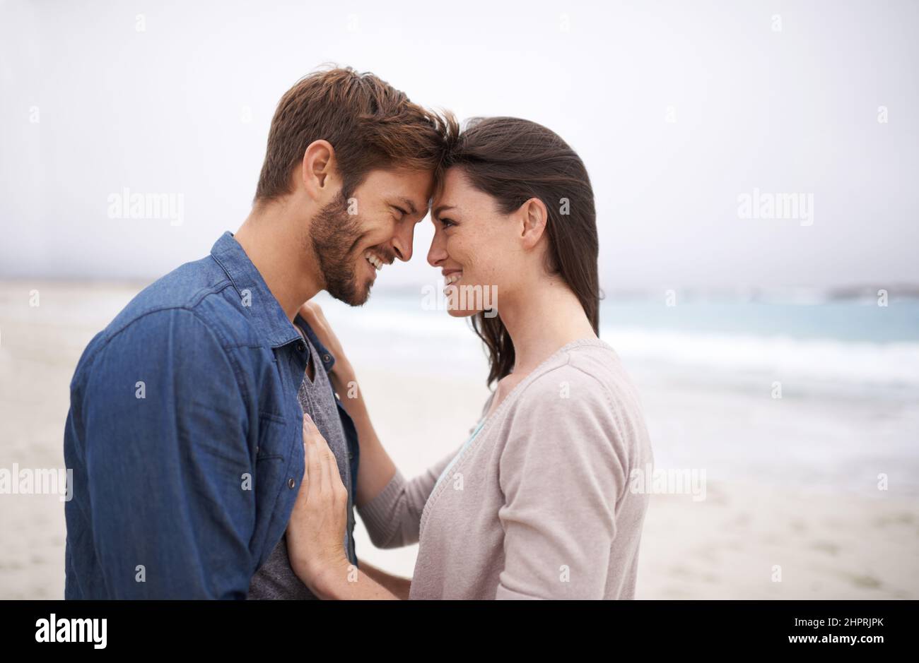 Die Natur bringt diese natürliche Art von Liebe zum Vorliegen. Eine kurze Aufnahme eines romantischen jungen Paares am Strand. Stockfoto