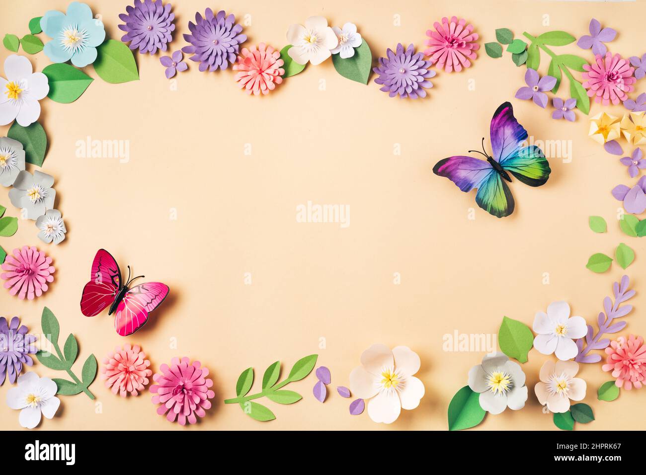 Flache Lage von floralen Hintergrund mit handgefertigten Papierblumen und Buttreflies. Papierkunst und Handarbeit. Draufsicht. Frühling oder Sommer Stockfoto