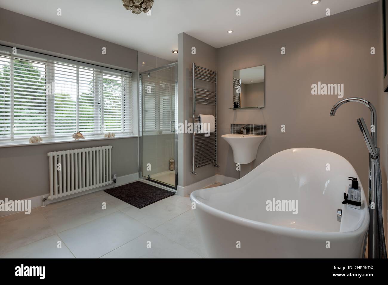 Swavesey, Cambridgeshire - August 22 2018: Modernes Luxusbad der Spitzklasse mit traditioneller Badewanne, Duschkabine, gefliestem Boden, Handtuchhalter und Handtuchhalter Stockfoto