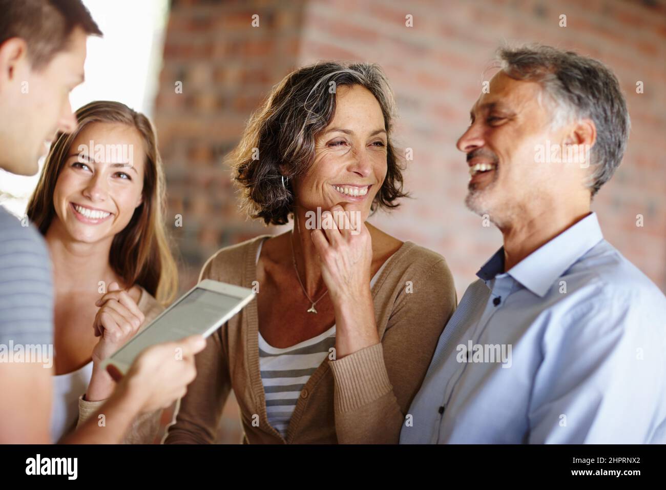 Die guten Nachrichten hoch zu fahren. Aufnahme einer glücklichen Familie, die eine Diskussion führt. Stockfoto