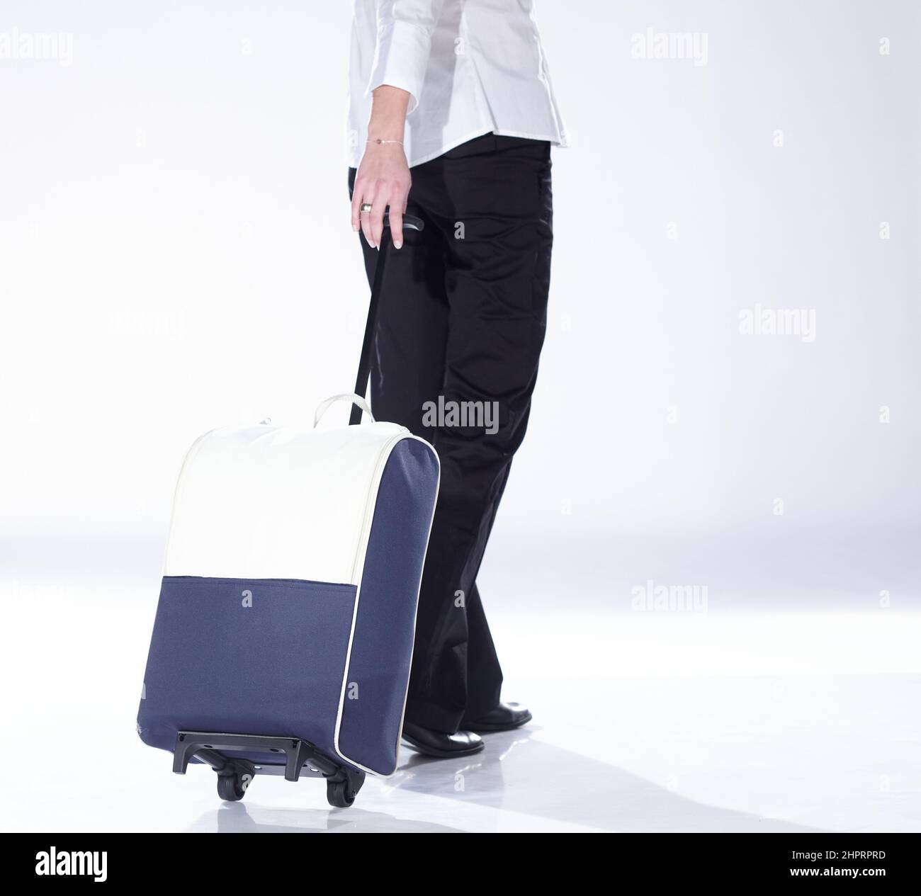 Eine Gastgeberin mit ihren Kostümen, die einen Koffer trägt, um auf eine Reise zu gehen. Stockfoto