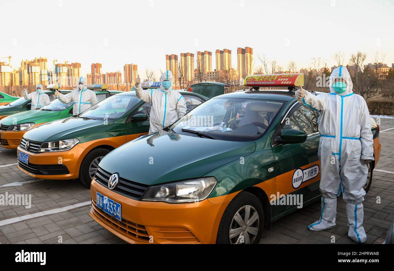 (220223) -- HOHHOT, 23. Februar 2022 (Xinhua) -- Zhao Yonghong (1st R) posiert für ein Foto mit anderen freiwilligen Taxifahrern in Hohhot, der Autonomen Region Innere Mongolei im Norden Chinas, 22. Februar 2022. Nach dem jüngsten COVID-19-Ausbruch in Hohhot hat sich der 55-jährige Taxifahrer Zhao Yonghong dazu entschlossen, als Freiwilliger an vorderster Front zu arbeiten, der auf seine Art und Weise zur Bekämpfung der Epidemie beitragen kann. Jeden Tag fährt Zhao zwischen Probenahmestellen und Testlabors, die vollständig mit Schutzausrüstung abgedeckt sind, hin und her und liefert Nukleinsäuretestproben. Derzeit haben sich mehr als 500 lokale Taxis der epidemischen Prävention der Stadt angeschlossen Stockfoto