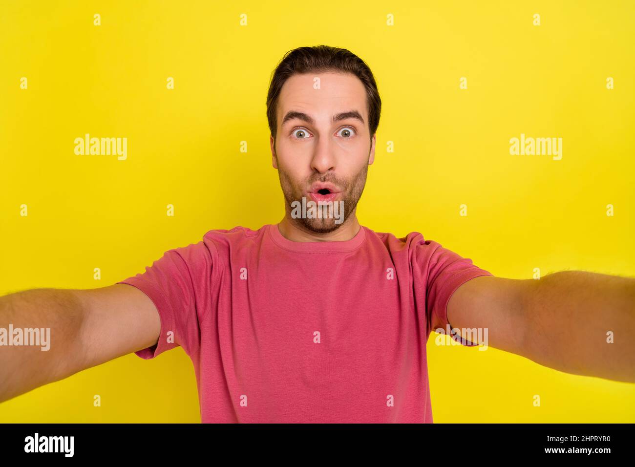 Foto von schockiert Influencer Kerl machen Selfie lustig omg Gesicht tragen rosa T-Shirt isoliert gelben Hintergrund Stockfoto