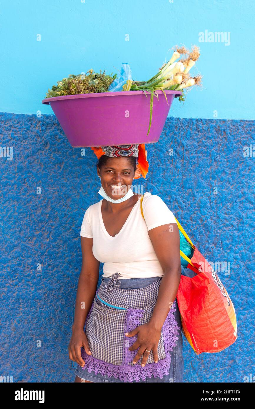 Frau, die eine Schüssel mit Gemüse auf dem Kopf trägt, Espargos, Sal (IIha do Sal), República de Cabo (Kap Verde) Stockfoto