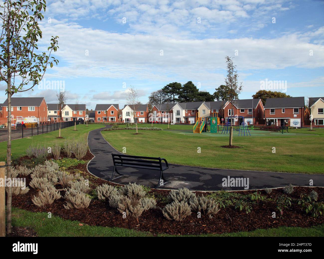 Grünflächen und Kinderspielplatz sind in eine moderne Wohnsiedlung in Wolverhampton, West Midlands, Großbritannien, integriert Stockfoto
