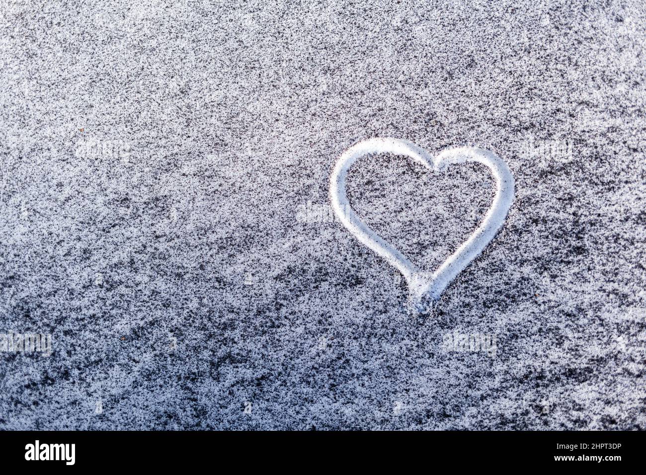 Schwarzer Ruß aus dem Kesselraum auf weißem Schnee. Natürlicher Hintergrund. Schnee gemischt mit Kohleroß, schlechte Ökologie. Umweltverschmutzung. Ein Herz ist schmerzhaft Stockfoto
