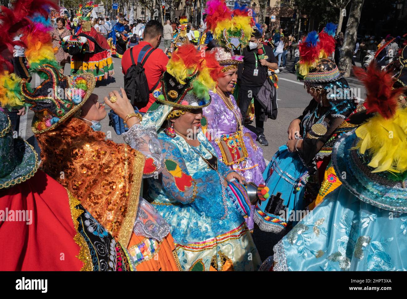 Bolivianische Frauen tragen traditionelle bestickte Kleider und farbenfrohe Hüte während einer Pause bei der Parade zum Hispanic Heritage Day in Barcelona, Spanien Stockfoto