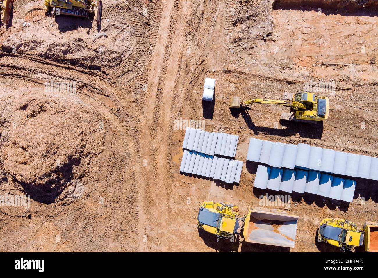 Luftaufnahme mit Vorbereitung des Grundstücks für den Bau neuer Beton-Rundrohre, die für die Kanalisation liegen Stockfoto