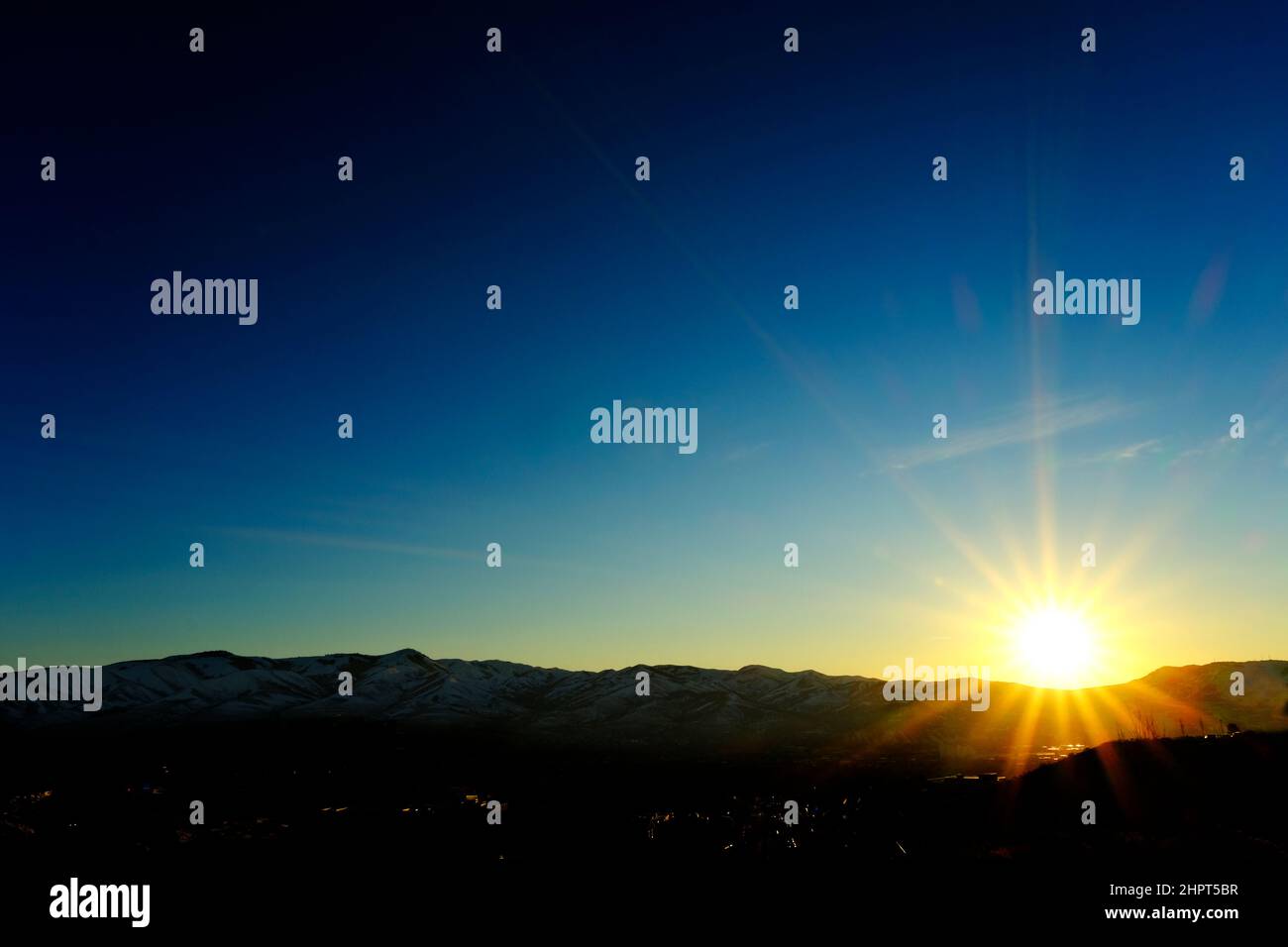 Sonnenstern Sie goldenes Sonnenlicht bei Sonnenuntergang oder Sonnenaufgang in einem wunderschönen blauen Himmel Stockfoto