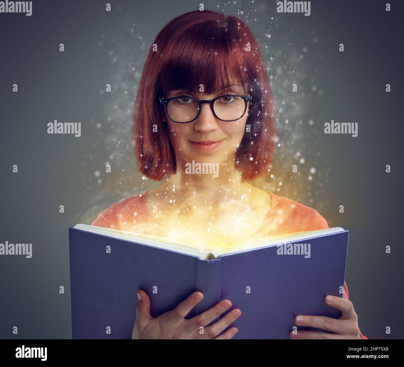 Öffnen Sie ein Buch... und beginnen Sie die Reise. Eine ausgeschnittene Aufnahme eines jungen Erwachsenen, der ein Buch mit leuchtenden Seiten liest. Stockfoto
