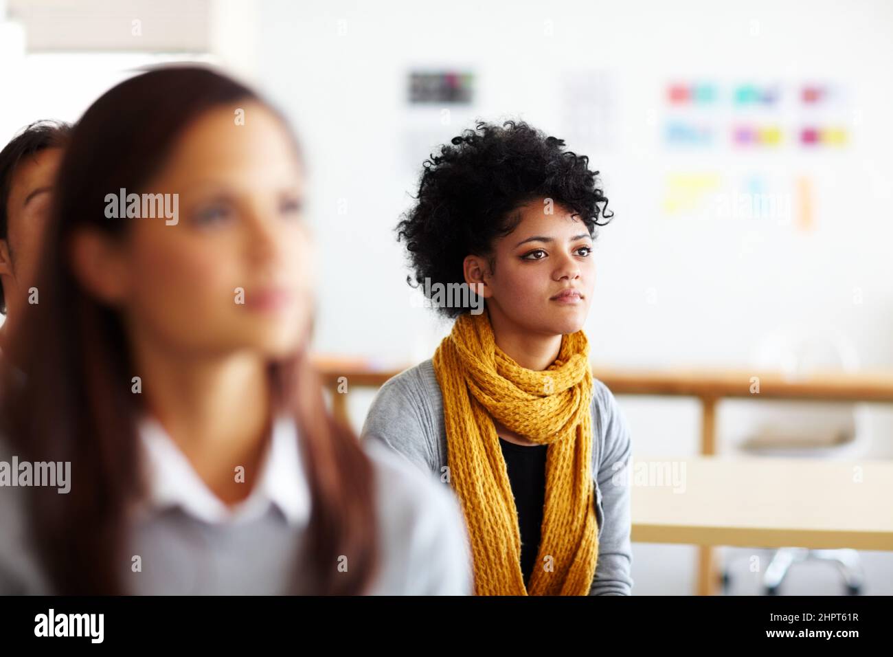 Achten Sie auf die Präsentation. Eine schöne junge Frau, die sitzt und einer Präsentation zuhört. Stockfoto